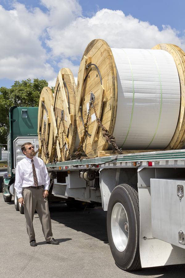 Flatbed truck loaded with reels of freight ready to ship